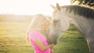 Mollie Vacco, with son and one of her horses.